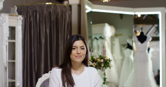4K Portrait beautiful Hispanic business owner in designer wedding gown boutique. Slow motion.