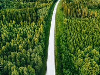 Aerial view from above of country road through the green summer forest in summer Finland. © NBLX