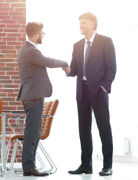 Two business people shake hands in the office