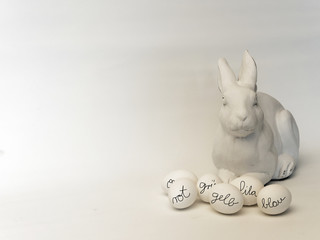 Osterdekoration: Osterhase mit Ostereiern in weißtoniger Farbgebung, Beschriftung der Eier mit...