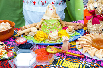 Shrovetide, pancake week, festival meal. Pancakes with caviar, honey, jam, curd, berries . Rustic style. Doll women of pancakes.