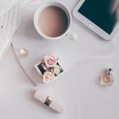 Women's accessories cup of coffee, lipstick, perfume, tablet on the table flat lay copy space