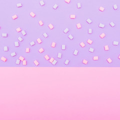 colorful marshmallow laid out on blue and pink background. pastel creative textures. minimal