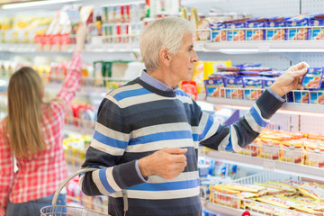 Elderly man shopping in supermarket