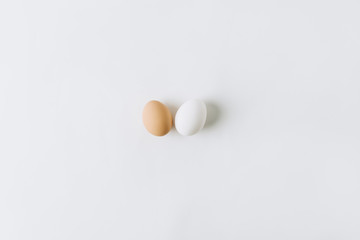 white and brown eggs laying on white background