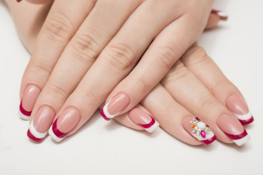 Manicure. White nails with red hearts. Isolated.