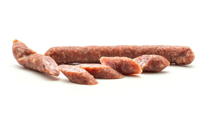 Hungarian dry sausages pepperoni isolated on white background smoked in natural casing mixed pork and beef one whole and one cut in five pieces.