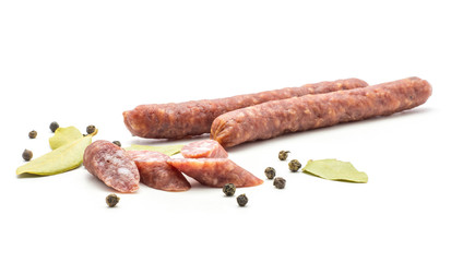 Two Hungarian dry sausages pepperoni with black pepper bay leaves and cut pieces isolated on white background smoked in natural casing mixed pork and beef.