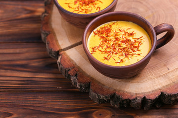 Indian turmeric milk with saffron, cardamom and turmeric. Copyspace