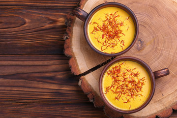 Indian turmeric milk with saffron, cardamom and turmeric. Copyspace