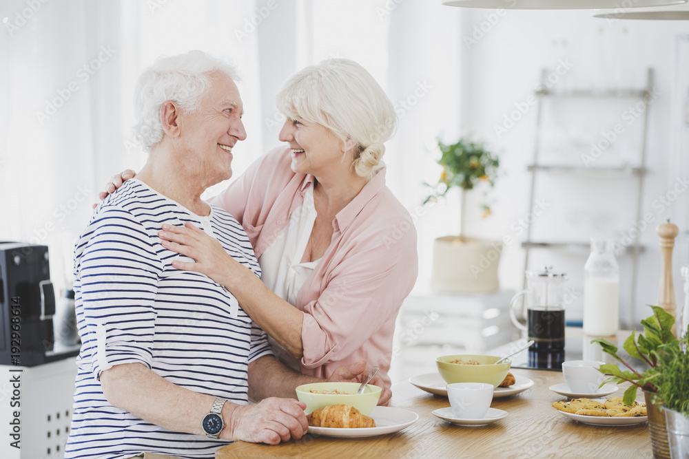 Wall mural Smiling senior woman hugging husband