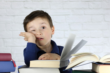 niño pequeño con cara de estres rodeado de libros