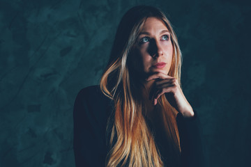 Young beautiful businesswoman thinks and looks away. Close up face model. Concept of thinking about the future. Cinematic look