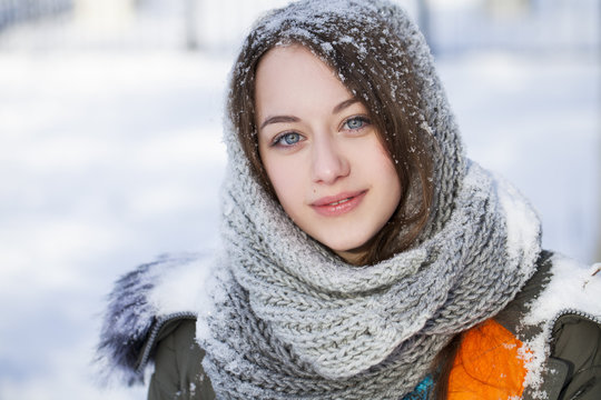 Portrait of young beautiful girl wearing white knitted scarf