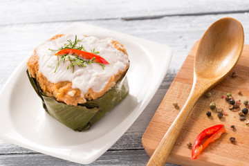 Curry Streamed Seafood in banana leaf cup on wood

