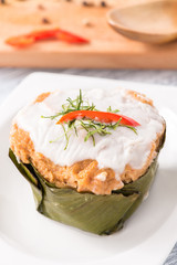 Curry Streamed Seafood in banana leaf cup on wood

