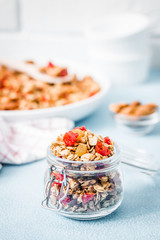 Orange cinnamon granola on light blue background. Selective focus, copy space.
