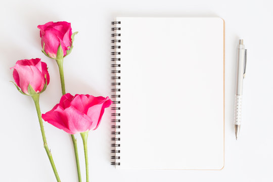 Blank notebook with pink roses and pen on white background,Flat lay photo of a notebook for your message,Valentine's Day concept