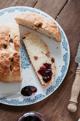 Freshly baked traditional German Easter Bread, Osterbrot, made of Brioche yeast dough with raisins and butter sliced on floral cake plate served as breakfast for Easter Sunday with currant jelly