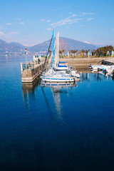 port with sailboats with background the lake and mountains on a bright morning,