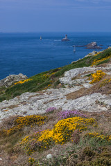 Rocky promontory Pointe du Raz and old lighthouse Phare de la Vieille in Brittany, France