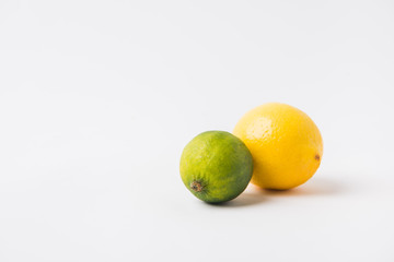 green lime and lemon laying on white background