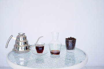 Serving coffee Hario v60 in a jug for smell, wooden. The background is blurred, all white. Side view with copy space