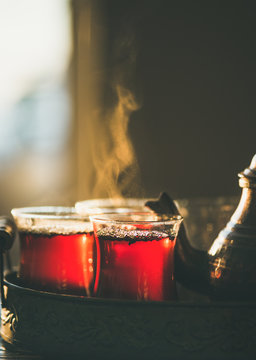 Freshly brewed black tea in turkish glasses and teapot in oriental tray, selective focus, close-up, copy space