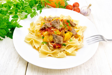 Farfalle with turkey and vegetables in sauce on table