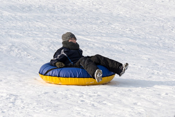 Fototapeta na wymiar child on snow tubing