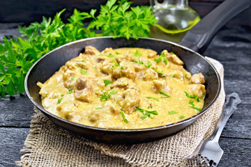 Meat stewed with cream in pan on burlap