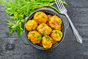 Meatballs in brazier with greens on board top