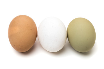 White, brown and green eggs in a row isolated