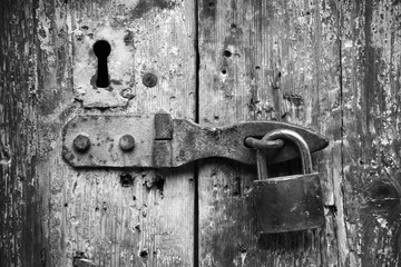 Old lock and rusted keyhole on wooden door