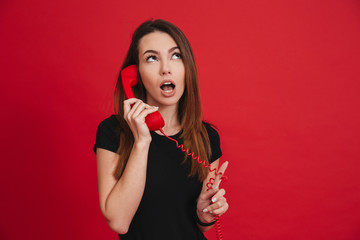 Portrait of a cute girl talking on a landline phone