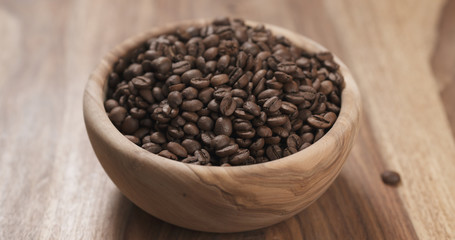 coffee beans in wood bowl on table