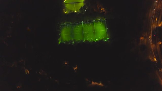 Footbal soccer field night aerial. Clip. Long exposure birds eye view of green footbal court. Top view of the football field at night