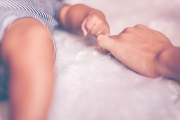 Newborn children's and mother hand touch each other. Mom and her Child. Happy Family concept. Beautiful conceptual image of maternity and baby care.