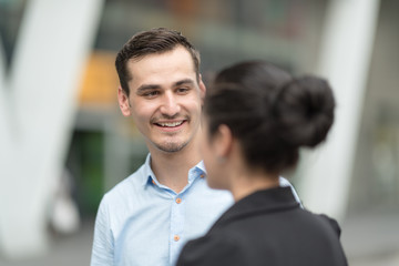 Two business colleagues in street city walk and talking to each other