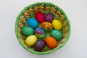 Easter eggs. Handmade painted eggs in basket for Easter celebration isolated on white background. Easter. Colored Easter eggs. Colorful egg. Copy space. Text space. Unique handmade painted eggs.