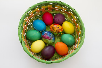 Easter eggs. Handmade painted eggs in basket for Easter celebration isolated on white background. Easter. Colored Easter eggs. Colorful egg. Copy space. Text space. Unique handmade painted eggs.