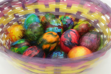 Easter eggs. Photo in motion effects during shooting. Not post process.  Handmade painted eggs in basket for Easter celebration isolated on white background. Easter. Colored Easter eggs.