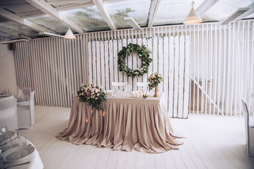 Table for the groom with the bride decorated with decorative elements and floral compositions