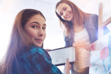 Results of my art class. Memorable moment of a girl smiling into the camera while taking a special certificate after taking painting classes in a painting studio for children.