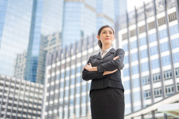 A Confident Business Female Arm Crossing Aganst Blur City Center Building Background.