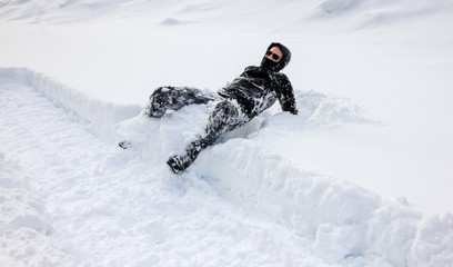 Man is falling into deep snow. Concept of winterly slippery conditions.