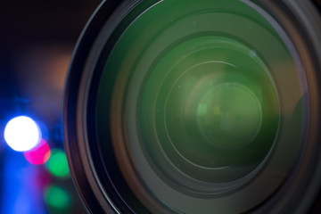 The photo or videocamera lens on dark background with lense reflections