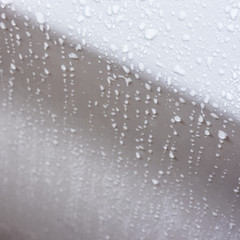 rain droplets on surface of white car body after shower
