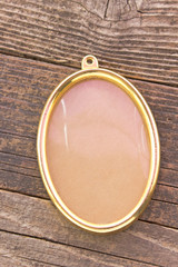 Golden oval frame on wooden background