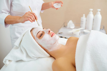 Obraz na płótnie Canvas Woman in mask on face in spa beauty salon.